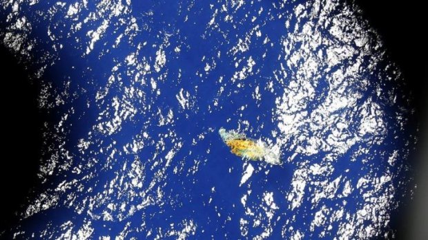 In this image taken onboard a Royal New Zealand P-3 Orion, a piece of unknown debris floats just under the water while the plane was searching for missing Malaysia Airlines Flight MH370 , in the southern Indian Ocean.