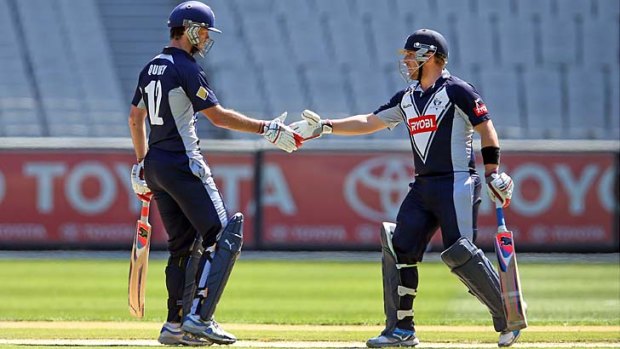 Opening batsmen Rob Quiney, left, and Aaron Finch shake hands after reaching their century partnership.