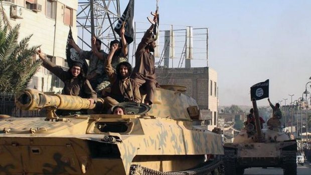 Islamic State fighters sit on a tank in Raqqa, Syria. 
