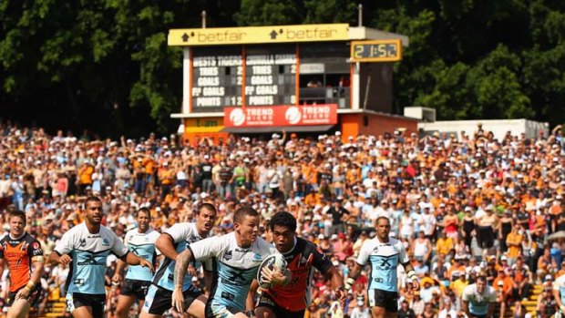 Cutting loose &#8230; Sharks recruit Todd Carney busts upfield at a packed Leichhardt Oval yesterday. Wests Tigers won 17-16.