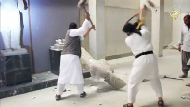 Islamic State militants use sledgehammers on a toppled statue in a museum at a location said to be Mosul in this image taken from an undated video. 