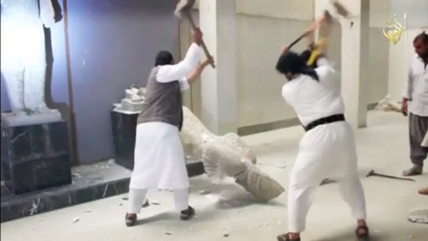 Jihadists use sledgehammers on a toppled statue in a museum at a location thought to be Mosul. 