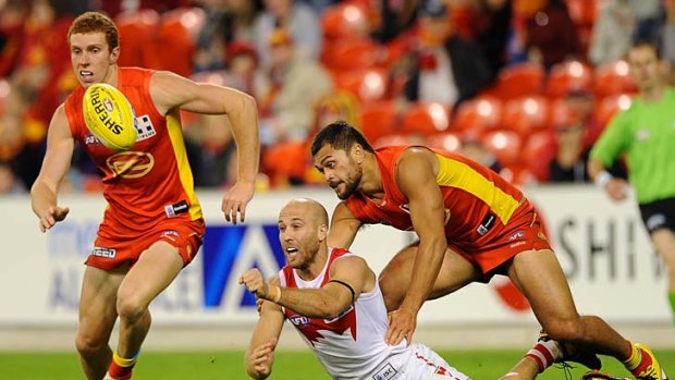 Hit out: A determined Jarrad McVeigh gets rid of the ball. With Ryan O'Keefe, he was a major ball-winner at Metricon Stadium last night.