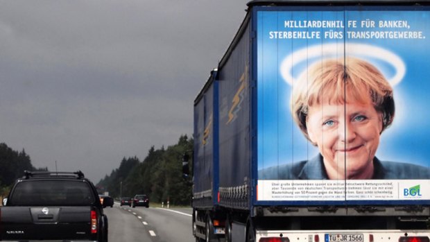 A portrait on the back of a truck of popular German Chancellor Angela Merkel, complete with halo.