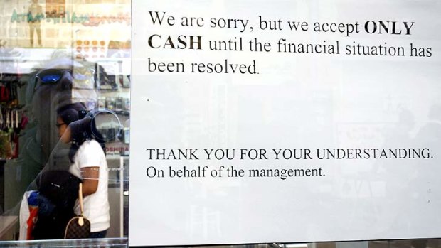 'Only cash' ... a sign hangs in a window of a store in Nicosia, Cyprus.