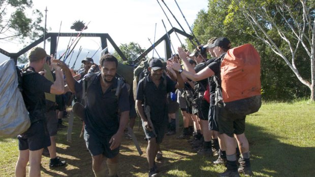 Police hikers hail their local porters with a guard of honour at the end of the Kokoda Track.