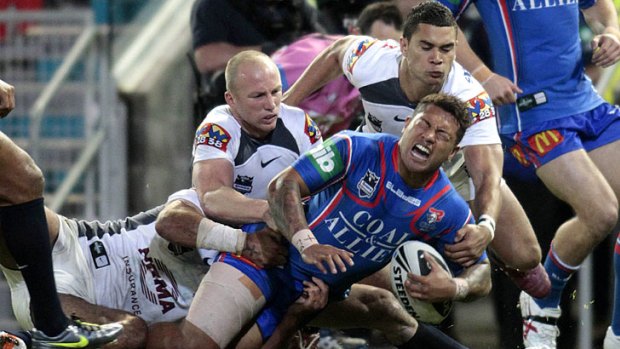 Crunch ... Junior Sa’u goes down with an ankle injury under a swarm of Broncos in Newcastle’s bruising and costly 20-point home loss to Brisbane last night.