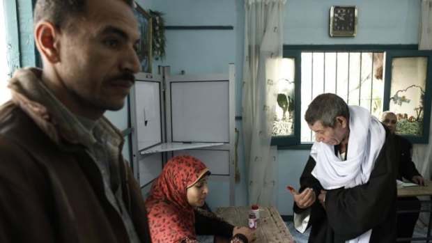 An Egyptian man inks his finger after casting her vote at a polling booth