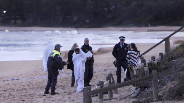 Police speak to distraught people on Pearl Beach after the boy went missing.