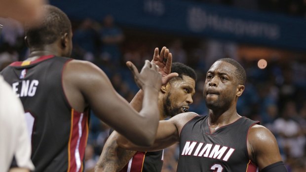 Job done: Dwyane Wade, right, and Luol Deng high five after winning Game Six.