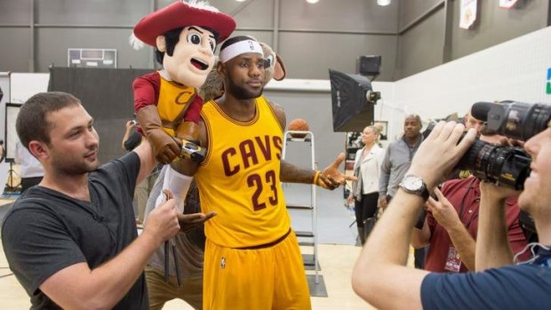 Fun and games: LeBron James records a promotional video during Cleveland's media day.