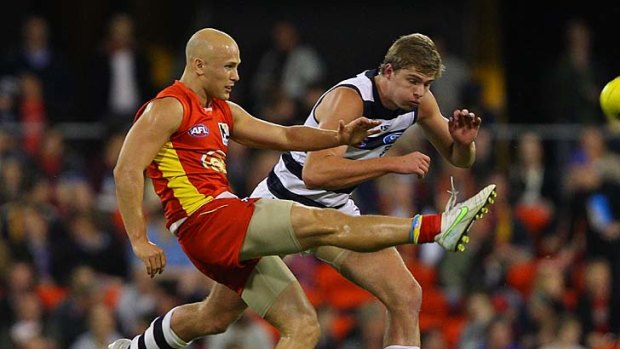 Gold Coast Suns captain and former Geelong champion Gary Ablett beats an attempted smother in the first AFL game at Metricon last night.