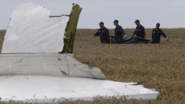 A body is removed from the crash site. Debris from the plane will contain missile fragments, experts say.