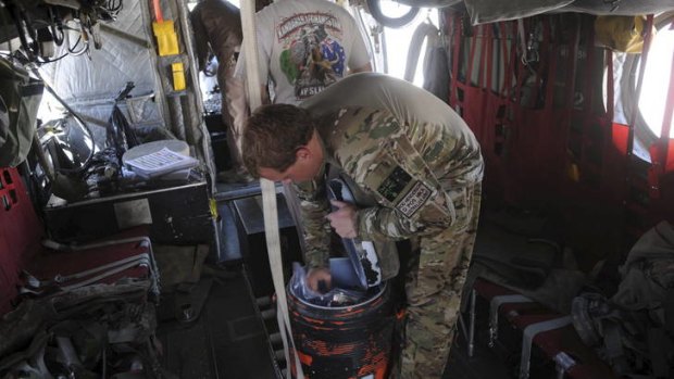 An Australian soldier reaches inside an esky in a Chinook Ch-47 D medium lift helicopter in Afghanistan.