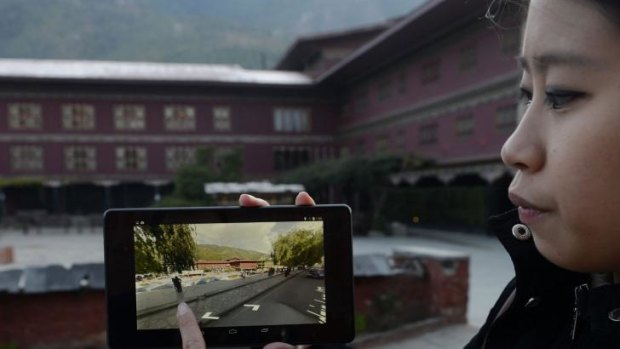 Google Product Communications Manager Stephanie Shih demonstrates a Google Street View image on a tablet computing device in downtown Thimphu.