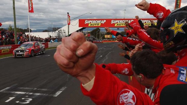 Close finish ... Holden's pit crew celebrates as Garth Tander crosses the line just ahead of rival Craig Lowndes.
