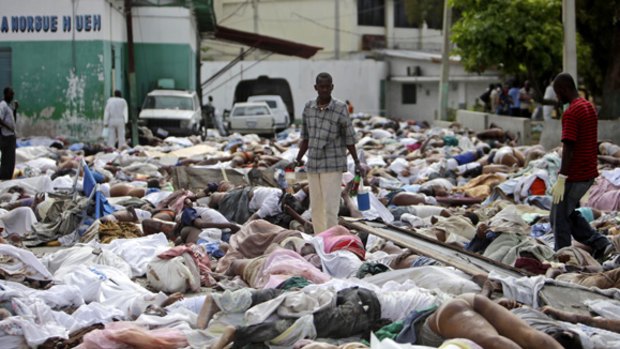 Very few cemeteries and little suitable land ... a man surveys hundreds of bodies outside the Port-au-Prince morgue.