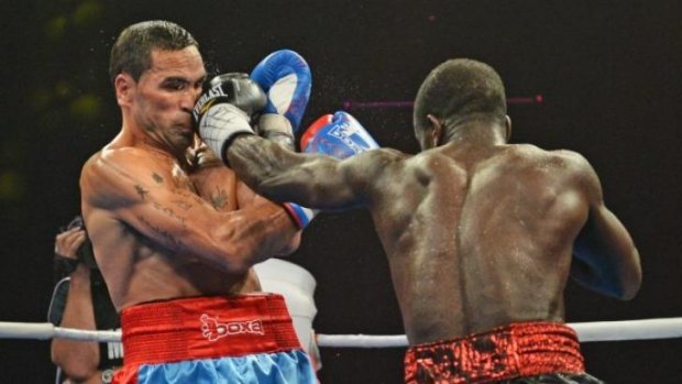 Blow by blow: Joshua Clottey (right) dishes out the punishment to Anthony Mundine.