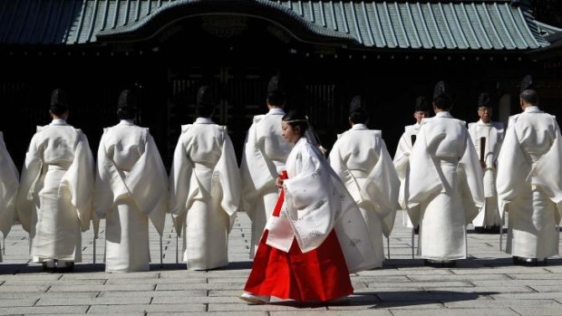Ritual: A shrine maiden walks behind shinto priests before a ritual to cleanse themselves at the Yasukuni Shrine during the Annual Autumn Festival in Tokyo, the same day Japanese PM Shinzo Abe sent an offering  to the controversial site that honours the nation's war dead.