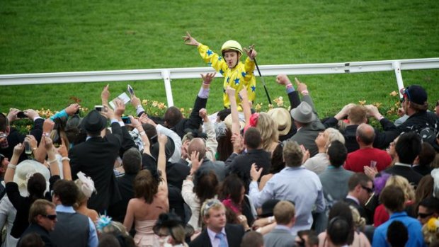 The crowd cheers Cristophe Lemaire after he rode Dunaden to a win at the Melbourne Cup.