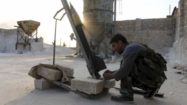 A Syrian rebel prepares to launch a rocket near Aleppo.