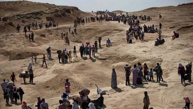 Displaced Iraqis from the northern town of Sinjar flee to the Kurdish autonomous region on Monday after the town fell to ISIL militants.