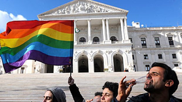 Gay activists celebrate in front of the Portuguese Parliament after the approval of a bill to legalise same-sex marriages.