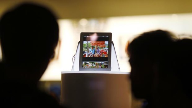 Passers-by look at a new iPad in a window display in an Apple store in downtown Sydney.