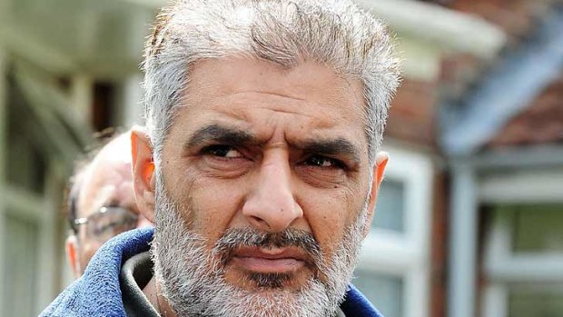 Tariq Jahan holds a picture of his son Haroon Jahan in Birmingham on Wednesday. Haroon Jahan died after being knocked down by a car along with two other men while protecting their community from looters.