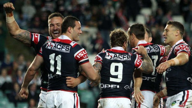 All smiles: Sydney Roosters players celebrate a Boyd Cordner try against the Sharks.