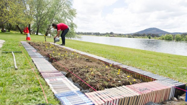 Brisbane artist Archie Moore with his work <i>Crop (noun/verb)</i> at Bowen Place. He has used encyclopedias as a border to a yam daisy garden to represent the clash of Western and Indigenous knowledge for the exhibition <i>Contour 556</i>. 