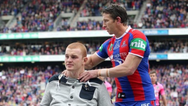Kurt Gidley comforts Alex McKinnon before the start of the round 19 match between the Knights and theTitans.
