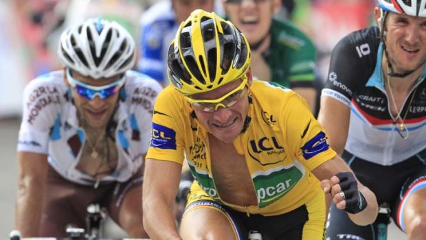 In yellow for another day ... Thomas Voeckler clenches his fist as he crosses the finish line of the 14th stage of the Tour de France.