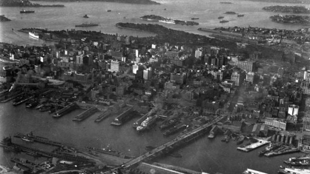 Sydney in the Depression years, probably about 1930. Height restrictions meant only medium-rise buildings, and - long before  Darling Harbour was transformed - cargo ships ruled and Pyrmont Bridge  took road traffic through an unattractive industrial area.