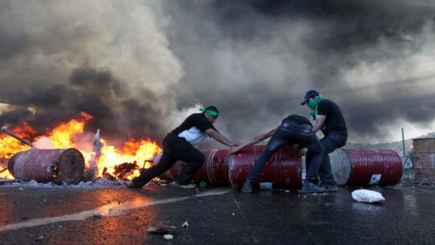 Palestinian protesters block Route 60, the main Jewish settler road in the West Bank.