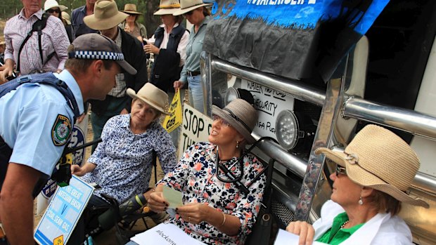 Narrabri farmer Kim Revell locks herself to a heavy vehicle trying to enter Santos' Leewood reverse-osmosis plant.