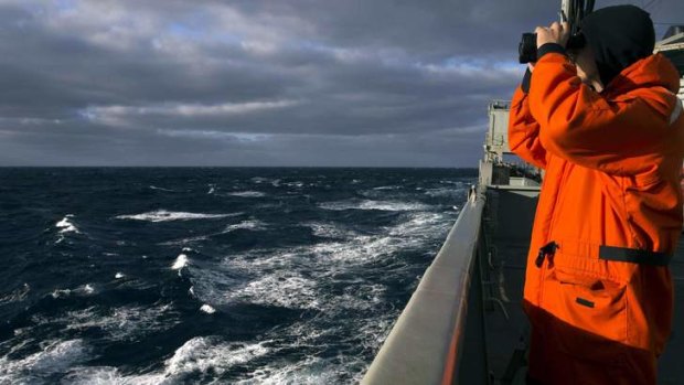 Able Seaman Marine Technician Matthew Oxley stands aboard the Australian Navy ship the HMAS Success looking for debris in the southern Indian Ocean.