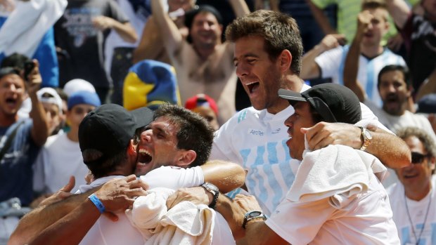 Federico Delbonis is mobbed by team captain Daniel Orsanic and teammates.