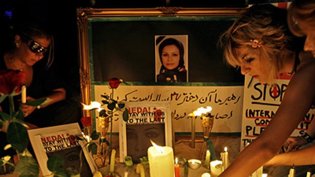 Shrine to a mourned victim ... Iranian women light candles in memory of Neda Agha Soltani whose death in Tehran last Saturday has sparked world anger.