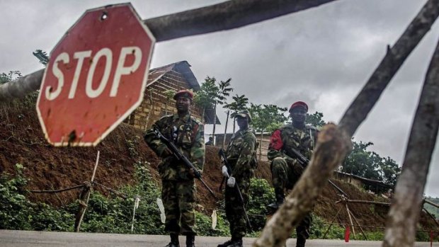 Soldiers stand guard at a roadblock outside Kenema, Sierra Leone.