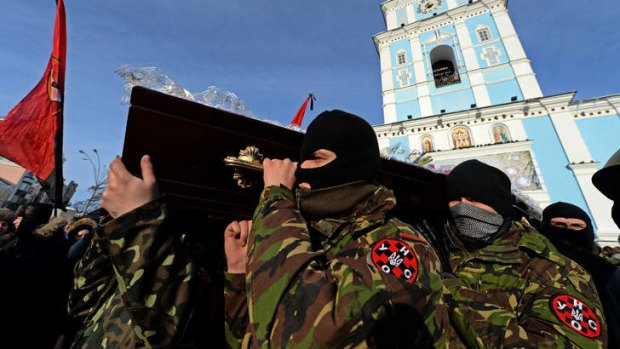Violent end: Ukrainian protesters carry the coffin of Belarussian protester Mikhail Zhiznevsky, who was killed in recent clashes with riot police, as demonstrators pay their respects outside Mikhaylovsky Cathedral in Kiev.
