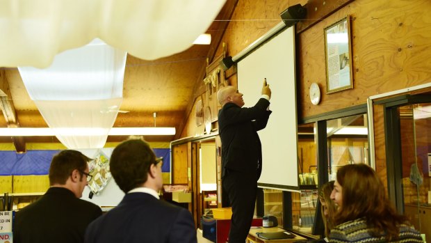 Adrian Piccoli photographs a story on a library wall about David Gonski's visit to Villawood North Public School. The issue of Gonski funding is on the education agenda.