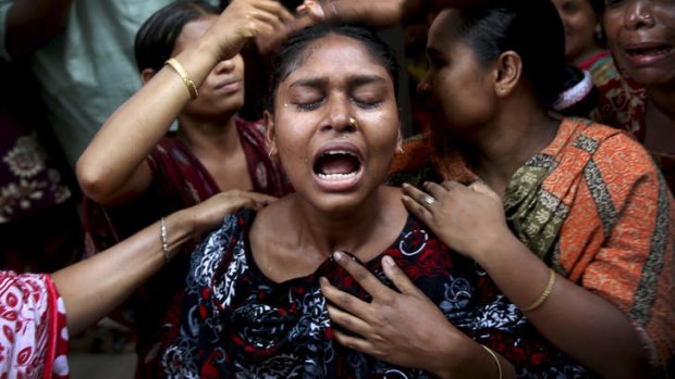 A woman is comforted by family members and others after she identified the body of her relative recovered from the rubble of the garment factory building which collapsed last week, in Savar, near Dhaka, Bangladesh.