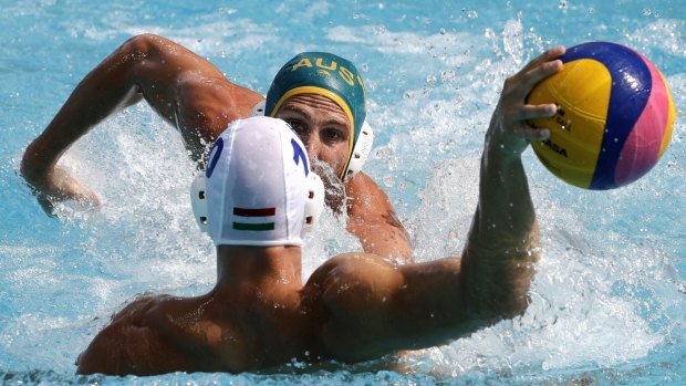 Hungary's Denes Varga takes a shot as Australia's Rhys Howden defends during their men's water polo preliminary round match on Monday.