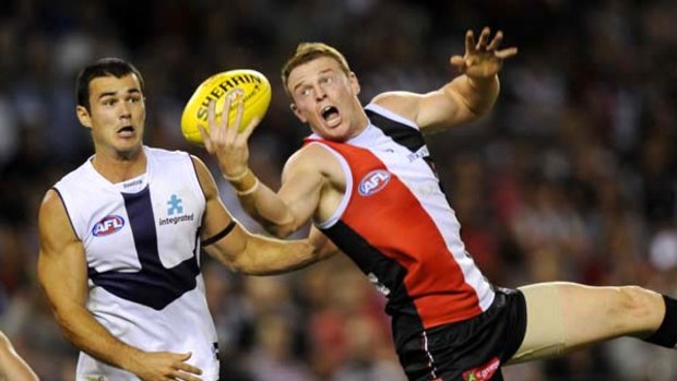 Brendon Goddard takes a one-handed mark in front of Chris Tarrant.