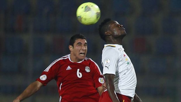 Ramy Rabiea (L) of Egypt fights for the ball with Asamoah Gyan of Ghana.