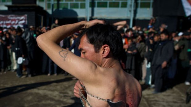 An Afghan Shiite man marks the festival by  beating himself with blades in a public display of grief.