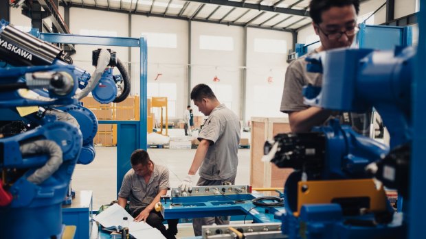 Workers assemble robots at a factory in Shenyang, China. While technology takes jobs away, it also creates complex tasks, leading to new roles.