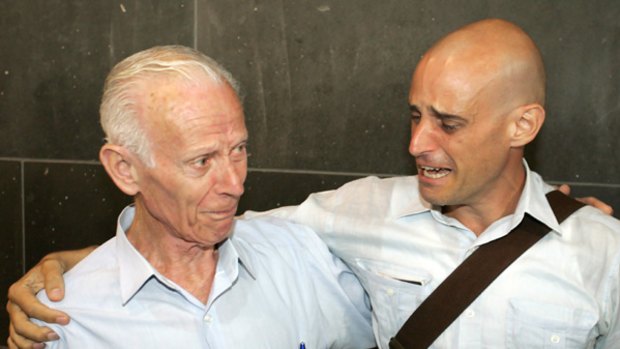 Australian author Harry Nicolaides (right) is reunited with his father Socrates (left) after arriving from Thailand at Melbourne Airport after being given a royal pardon.