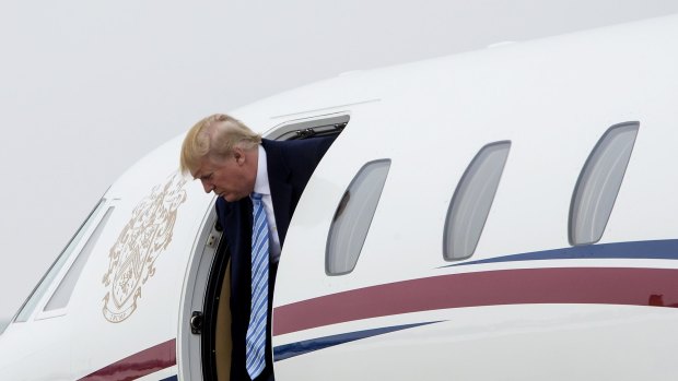 Welcome to the new age of conspicuous consumption: Donald Trump as he exits his private Cessna jet.